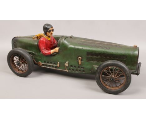 A fiberglass model of a vintage motor car and driver. 