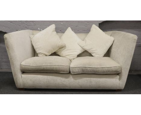 A large high back three seat sofa with cream upholstery. 
