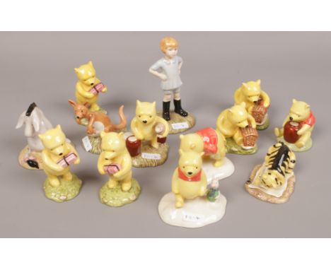 A collection of Royal Doulton Winnie the Pooh ceramic figurines, Kanga and Roo, Christopher Robin, Eeyore's tail examples. 