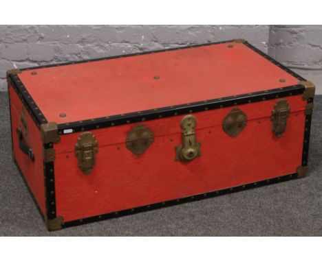 A red twin handle travel trunk. 