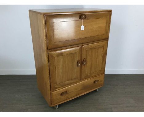 ERCOL, WINDSOR MODEL 469 ELM SIDE CABINET CIRCA 1960/70s the fall front enclosing fitted interior, over two cupboard doors an