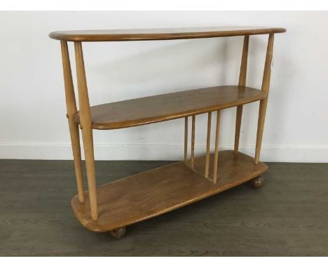 ERCOL, WINDSOR MODEL 361 'BABY GIRAFFE' ELM TROLLEY BOOKCASE CIRCA 1960-69 with three tiers on tapered birch supports, the lo