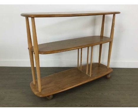 ERCOL, WINDSOR MODEL 361 'BABY GIRAFFE' ELM TROLLEY BOOKCASE CIRCA 1960-69 with three tiers on tapered birch supports, the lo