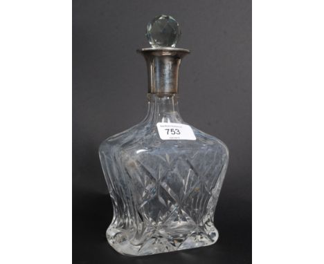 A silver hallmarked topped cut glass drinks decanter with stopper.