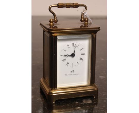 A Matthew Norman brass miniature carriage clock. The movement inscribed to rear having glass panels with handle atop. 
