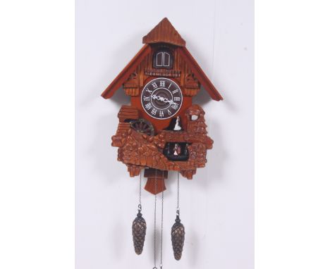 A contemporary cuckoo clock having central action with chains and weights beneath