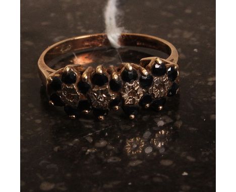 A ladies 9ct gold and diamond ring having black stone surrounds. Size M. Weight 2,6g.