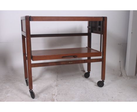 A vintage metamorphic two tier tea trolley by Tri-Magic. The top having swivel action to create a large top surface. Measures