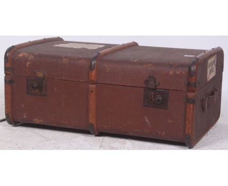 An early 20th century canvas and wooden bound steamer trunk with hinged centre complete with lined interior and tray