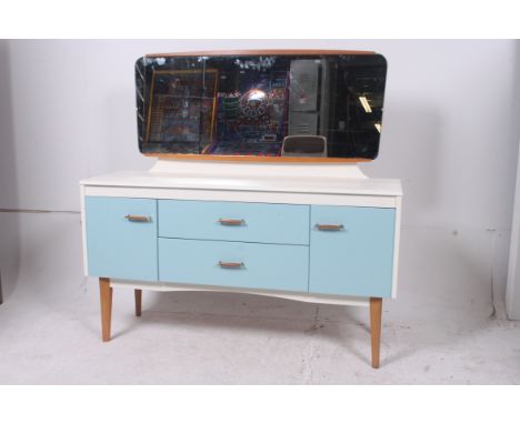 A vintage upcycled Lebus dressing table being painted duck egg blue and white with a series of cupboards and drawers being ra