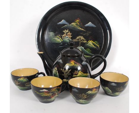 An early 20th century Chinese oriental lacquered wooden tea set including cups, saucers and tray.