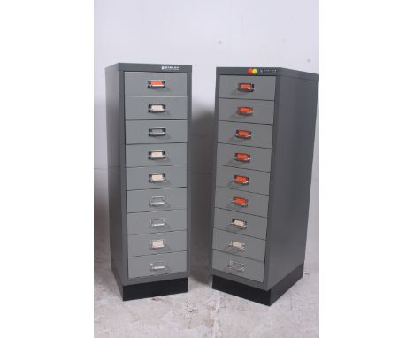 A pair of 1970's dark grey enamel painted metal industrial pedestal filing cabinets by Bisley. Each drawers with notation sli