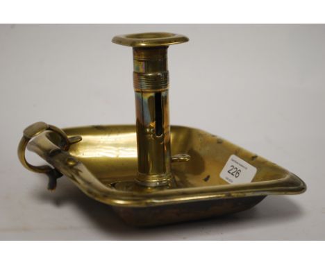 A 19th century Georgian brass chamberstick / candle stick. The tray base with turned column to centre