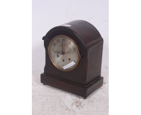 An early 20th century mahogany and silvered dial quarter chiming mantel clock. The dome case with glass face hacing German br