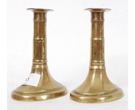 A pair of Georgian pusher brass candlestick holders, fluted design with ribbing to central shaft
