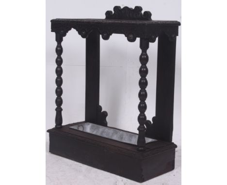 A 19th century Jacobean revival carved oak stick stand having inset trays to base with carved details to the top. Measures: 7