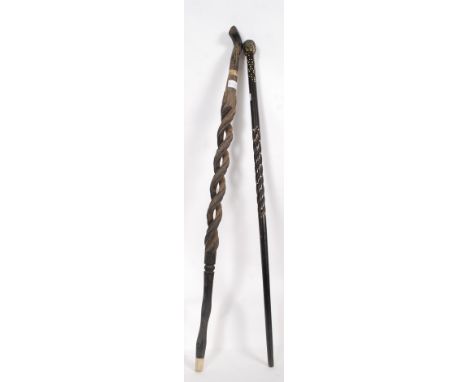 2 carved African tribal walking sticks, one with barleytwist design with Carved top  together with a ebony and bone inlaid wa