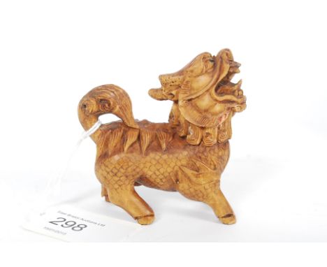 An intricate carved netsuke style temple dog / dragon with inset black eyes.