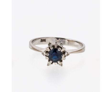   Ring  Ring   WG, 585. Kleiner sternförmiger Kopf, Ø 1 cm, besetzt mit einem  rund facettierten Saphir und sechs Achtkantdia