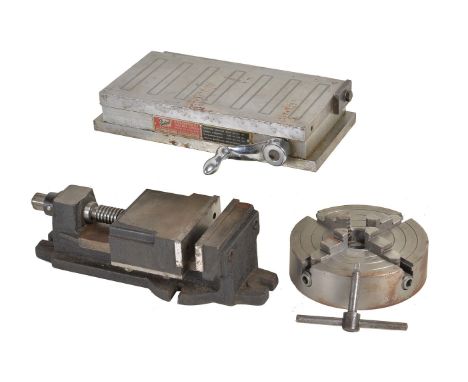 A magnetic milling vice, manual operated milling vice and a four-jaw lathe chuck.