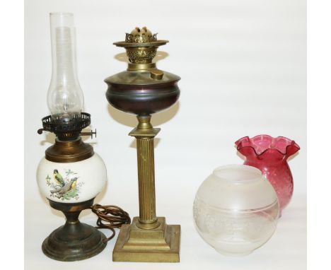 Two early 20th century oil lamps: one converted to electric, with ceramic body decorated with birds, and another with column 