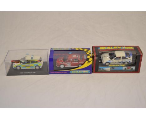 Three 1/32 scalextric slot cars: A Ford Focus Police Car with siren and flashing lights. Model in excellent little used condi