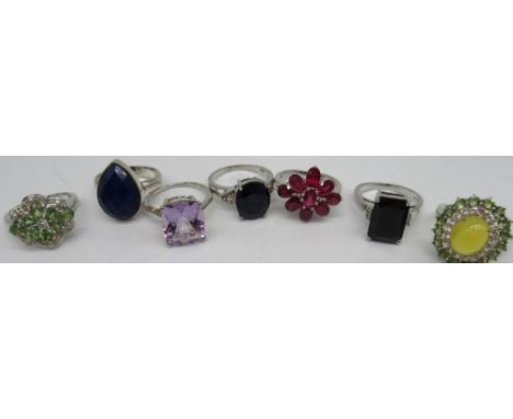 Seven hallmarked sterling silver rings set with various gemstones including opal, garnet, topaz, sapphire and lapiz lazuli, g