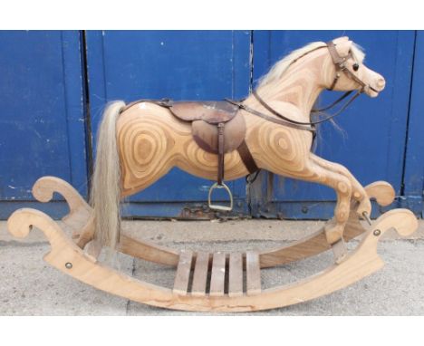 C20th rocking horse, ply construction on bow rocker base, cream mane and tail with leather saddle, bit and bridle, L150cm, H1