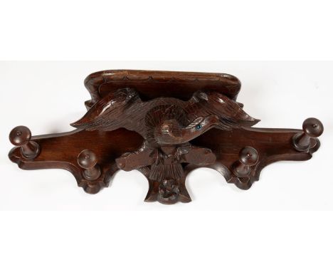 A CARVED AND STAINED WOOD HALL SHELF WITH COAT HOOKS IN THE FORM OF AN EAGLE DISPLAYED, 70CM L 