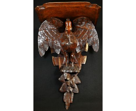 A 19th century oak wall bracket, carved as a pelican in her piety, shaped plateau, 52cm high, 35cm wide, c.1880 