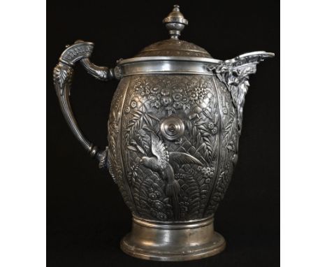 A 19th century pewter baluster flagon, elaborately cast  in relief with parrots in reserves of extensive flowers and fecund f