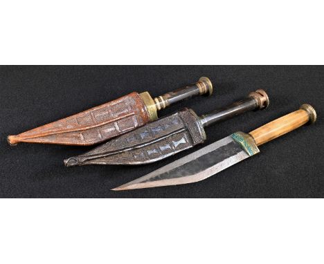 A Somali billao dagger, 15cm tapered double-edged blade, horn grip, brass pommel, 26cm long overall; another, similar, stacke