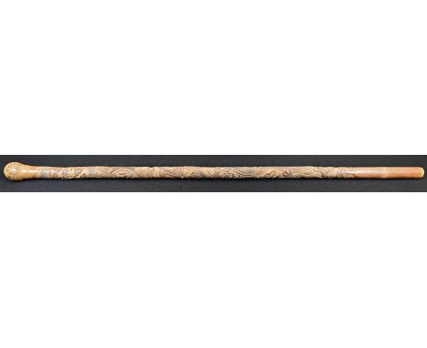 A Japanese bamboo walking stick, carved in relief with ferocious dragons amongst scrolling clouds, 89cm long, Meiji period 