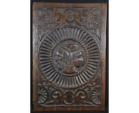 An 18th century oak panel, carved with a roundel of Classical portrait busts, back-to-back, on a field of strapwork and demi-