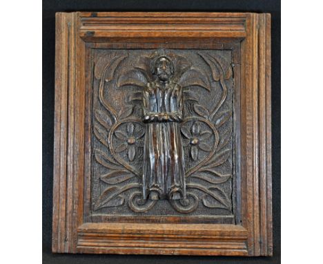 An 18th century oak rectangular panel, carved with a field of flowering scrolling leafy branches, applied with a figure of a 