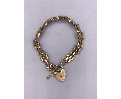 A 9ct yellow gold gate bracelet with heart shaped fastener. (7.7g)