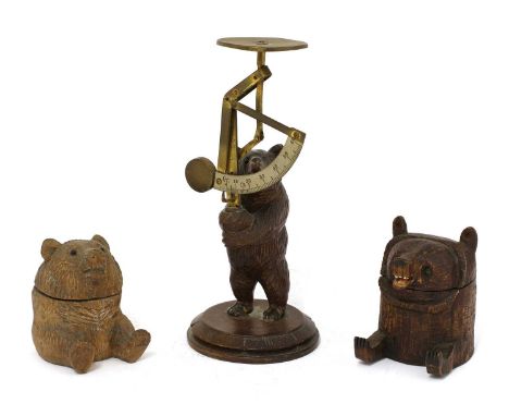 A carved wooden Black Forest postal scale,late 19th century, with carved bear support,19cm high,together with two inkwells in