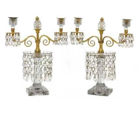 A pair of table lustres,early 19th century, each with two gilt metal branches, crisply cut sconces, a pineapple finial and lo
