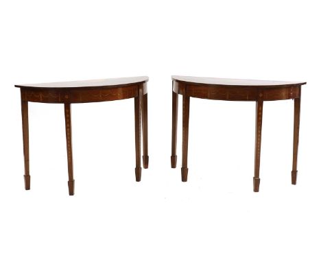 A pair of George III inlaid mahogany demilune console tables, each top with leaf-decorated satinwood crossbanding and central