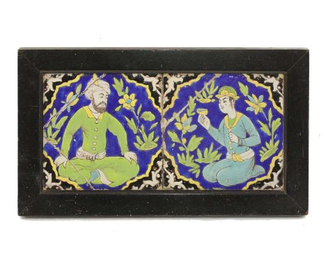 A Qajar cuerda seca pottery tile panel, 19th century, comprising two tiles decorated in polychrome with a seated bearded male