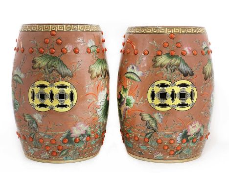 A pair of Chinese porcelain garden seats,20th century, of barrel shape, each painted in enamels with lotus flowers on a pink 