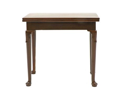 A small George II mahogany card table, the folding rectangular top enclosing a leather playing surface, candle and counter we