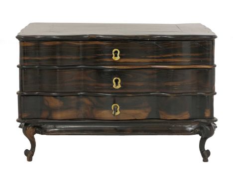 A Sri Lankan calamander miniature commode,19th century, of serpentine shape with three drawers on scrolled legs,38cm wide25.5