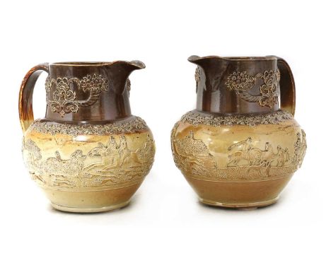 A pair of large stoneware jugs, 19th century, each decorated with sprigged decoration of hunting scenes, 28cm wide27cm high (