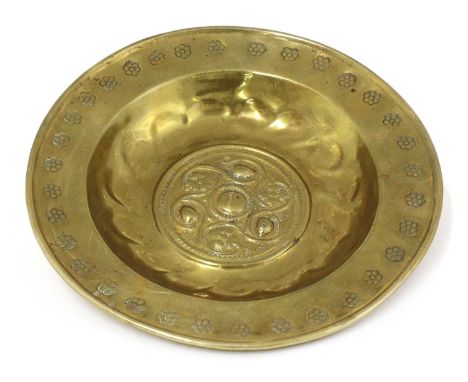 A small brass alms dish,16th century, Nuremberg, the rim stamped with flower head design around a lobed bowl,21cm diameterCon