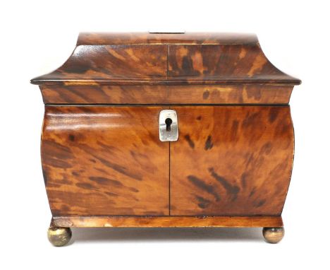 A tortoiseshell tea caddy,mid-19th century, of sarcophagus form, opening to reveal two divisions within, raised on gilt ball 
