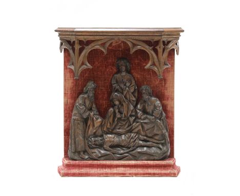 A Flemish carved walnut relief,probably 17th century, 'The Lamentation of Christ', on a later fabric-covered mount, surmounte