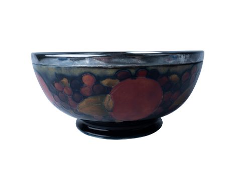 A distinguished example of early 20th-century craftsmanship, this Moorcroft ceramic bowl is adorned with the iconic Pomegrana