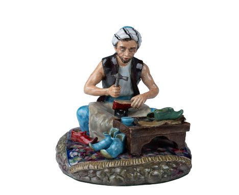 A finely detailed ceramic figurine depicting the Cobbler of Baghdad. This highly intricate piece captures a traditional craft
