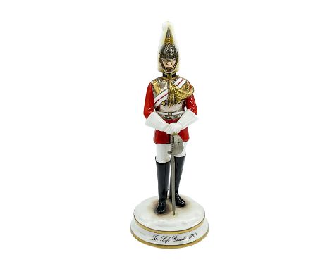 Porcelain modelled as a poised man in military uniform holding a metal sword. Gold and silver accents seen throughout. Michae